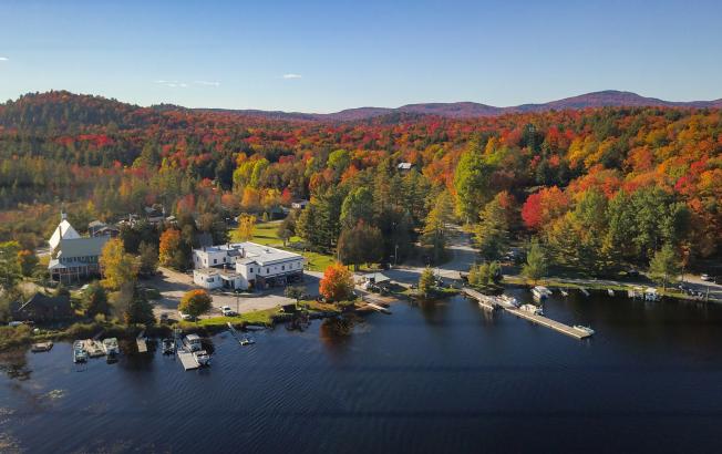 A dock on a lake surrounded by fall foliage.
