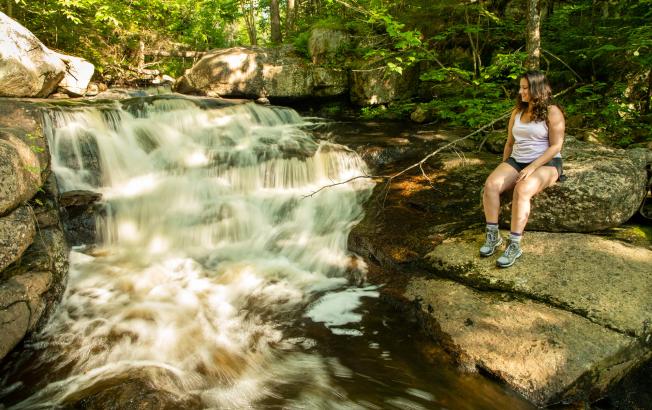 A woman next to a waterfall