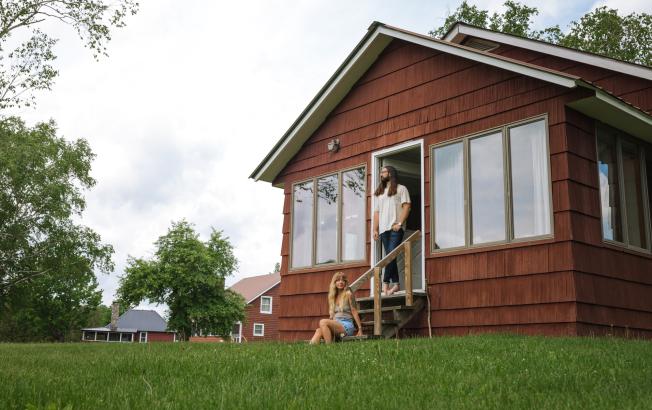 A couple in front of a cabin.