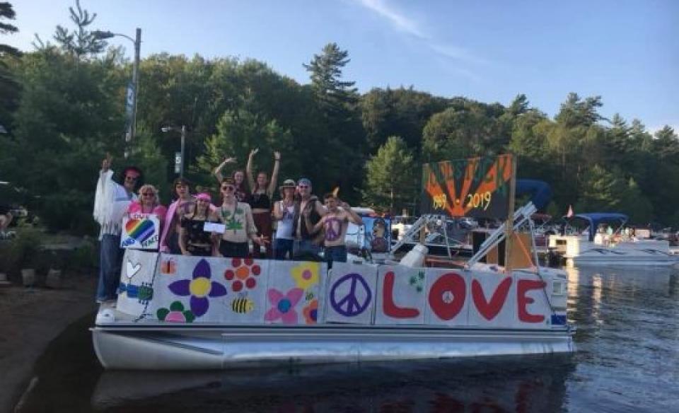 a pontoon boat with many people on board for a boat parade