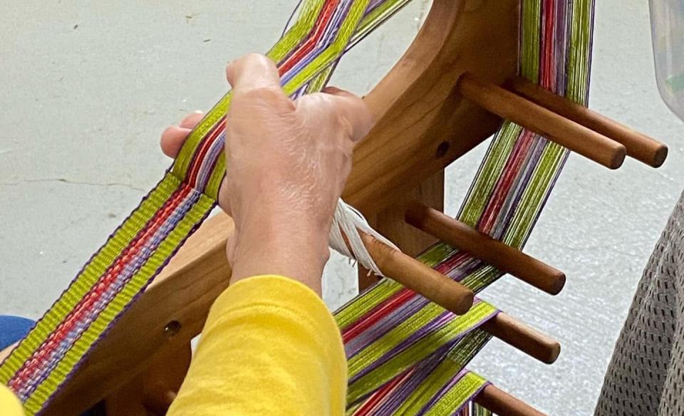 A woman creating fiber arts on a loom