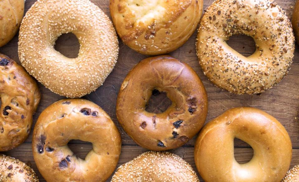A photo of a variety of bagels laid out on a wooden board