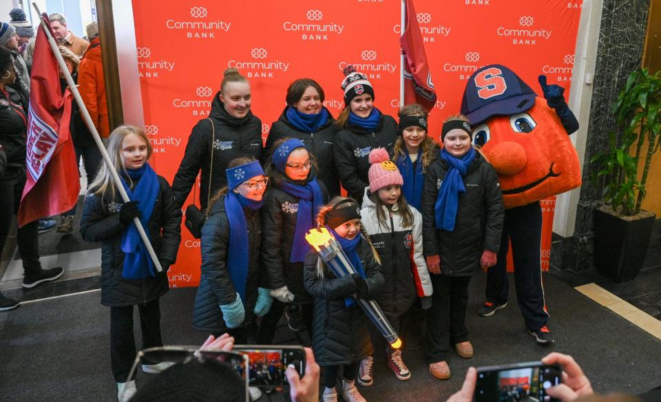 A smiling athlete stands proudly by a large ice sculpture for the 2025 ESWG