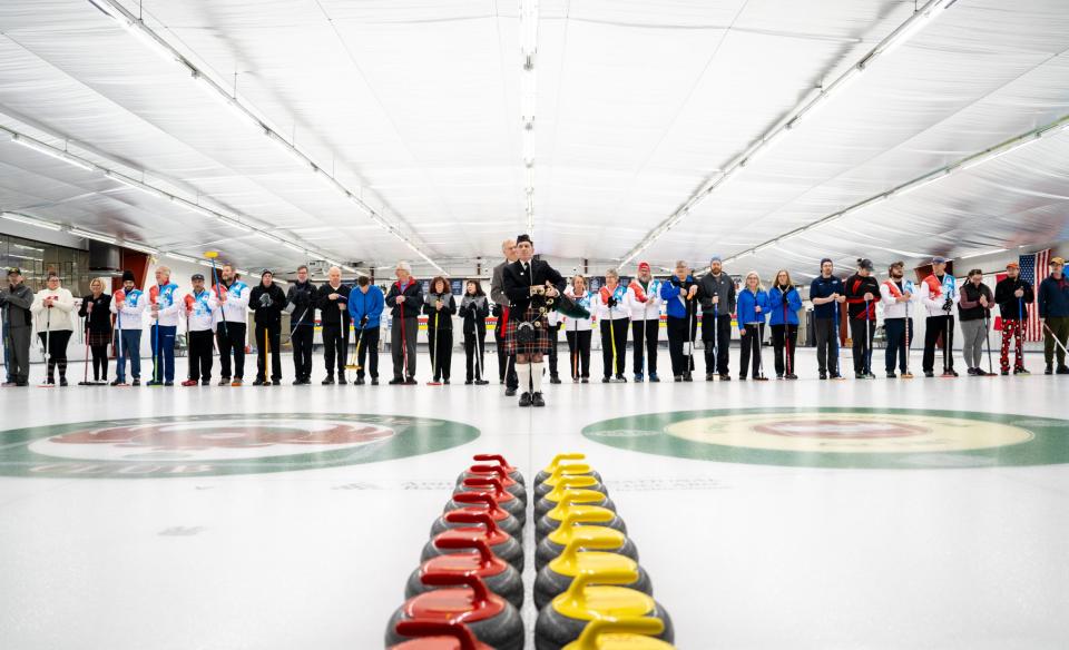 A sled hockey team in plaid jerseys celebrates on the ice during a game