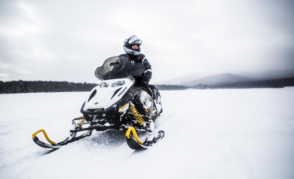 person sitting on a snowmobile on a snow covered frozen lake