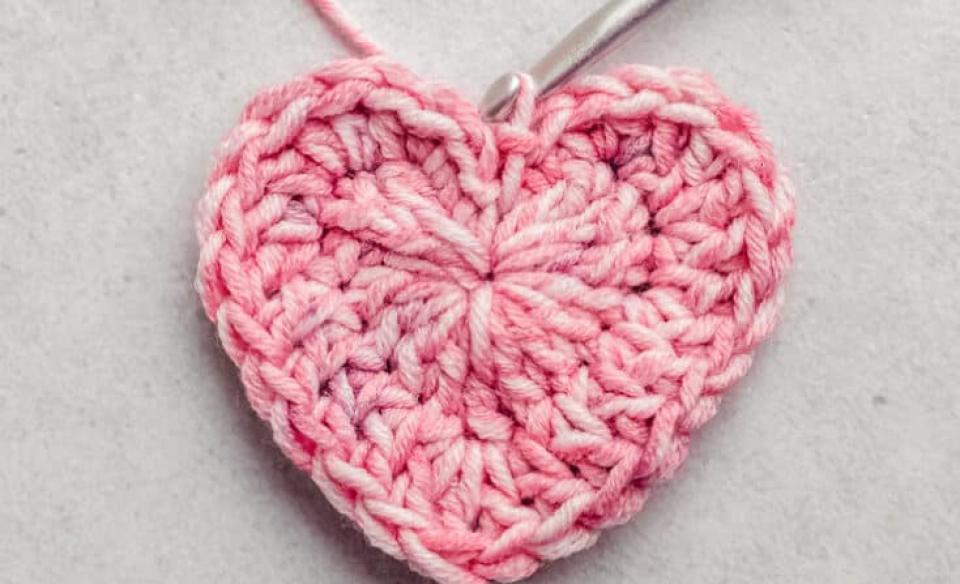 A photo of a crocheted heart with a crochet needle