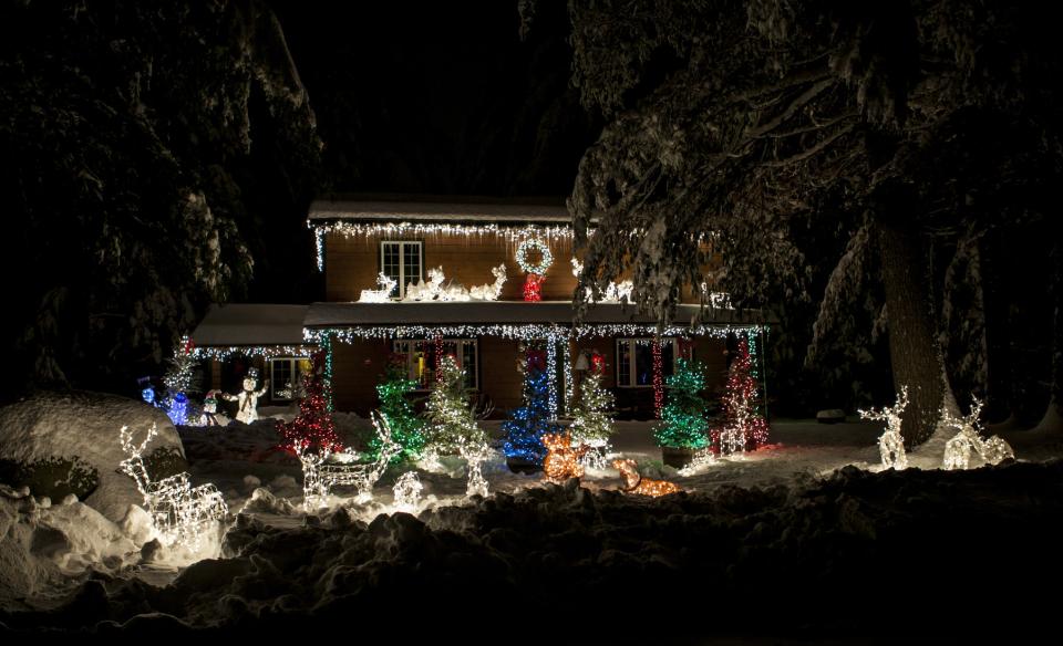 A  photo of a home decorated with lights and figures of deer
