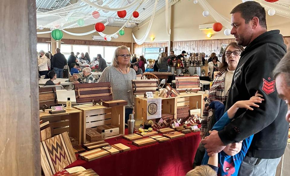 Vendor selling hand-made wooden objects like cutting boards
