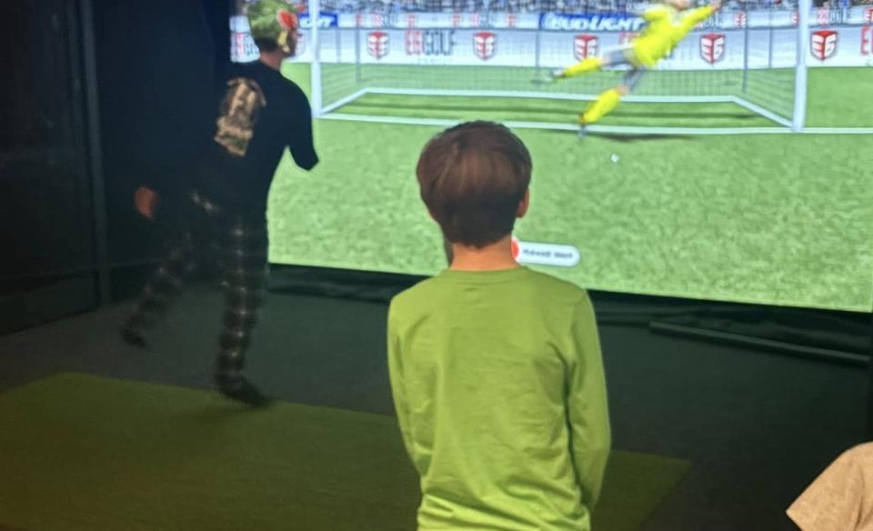 a few kids playing the virtual soccer game