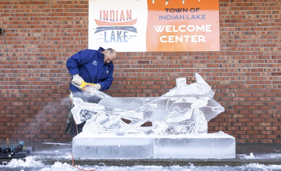 Man carving a snowmobile out of ice