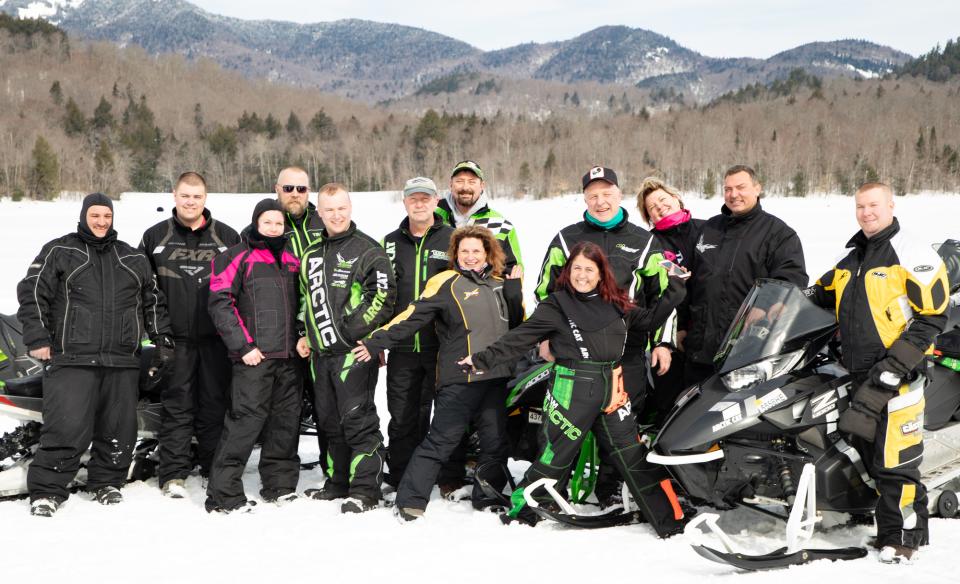 a group of snowmobilers pose for a photo