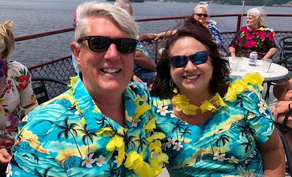 A man and his wife wearing matching hawaiian shirts and yellow leis on board the Durant