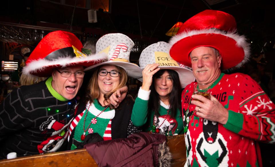 a group of four people posing for a photoall dressed up in ugly sweaters and crazy hates
