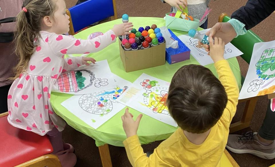 Children at a table coloring easter pictures