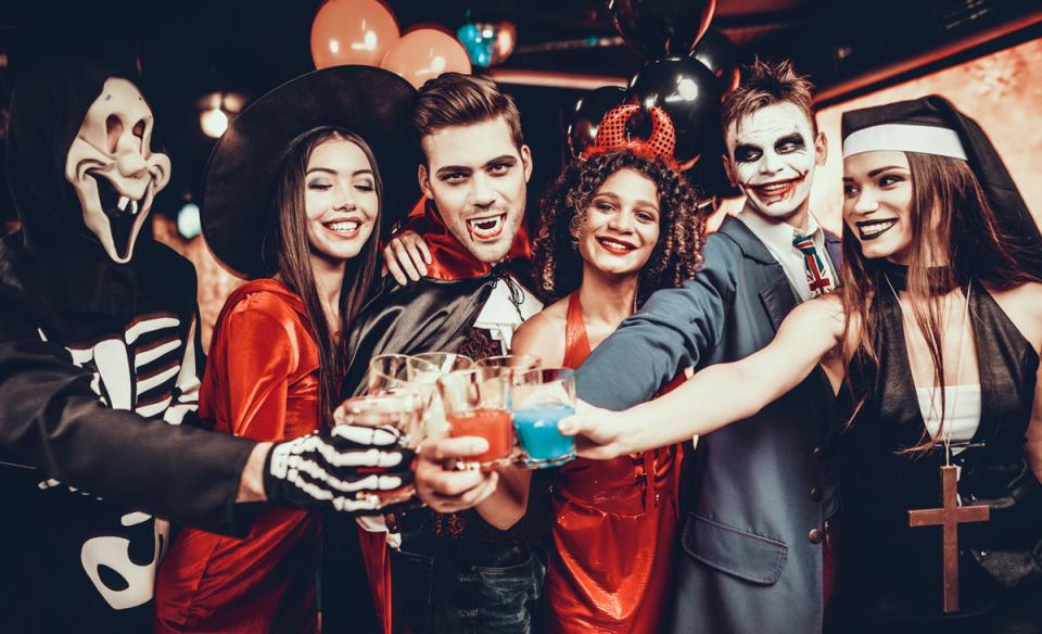 Several adults dressed up for Halloween toasting with special drinks