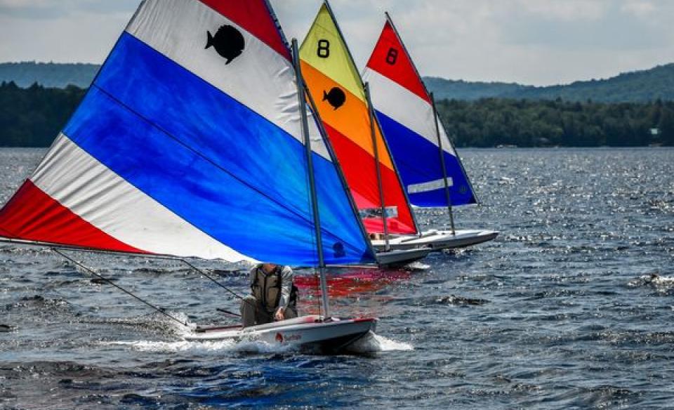Three sail boats riding parallel to each other
