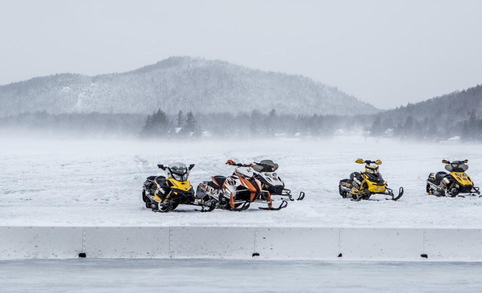 leaving tracks behind. Mountains are silhouetted in the background under a dusk sky.