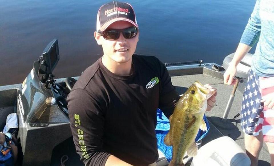 Angler holds up his catch in the fishing derby