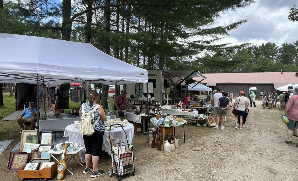 vendor at Brimfield and people shopping
