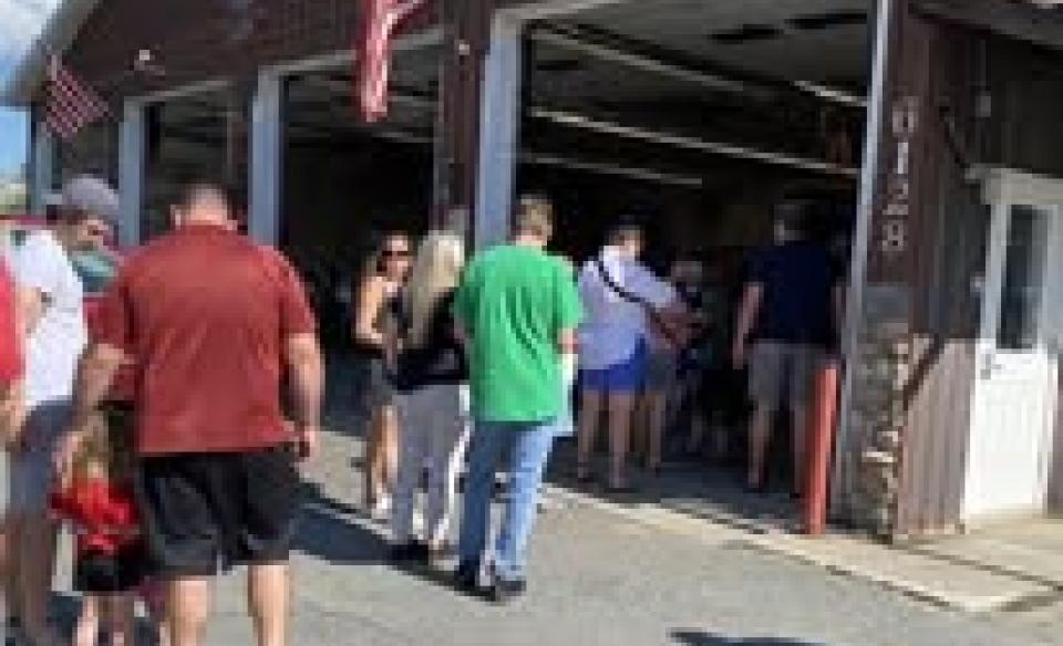 People in line at the fire department to get their chicken bbq dinner