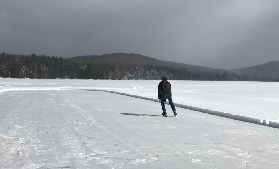 A man ice skating on the frozen lake