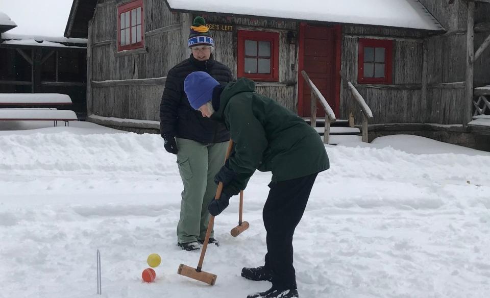a couple of people playing snow croquet