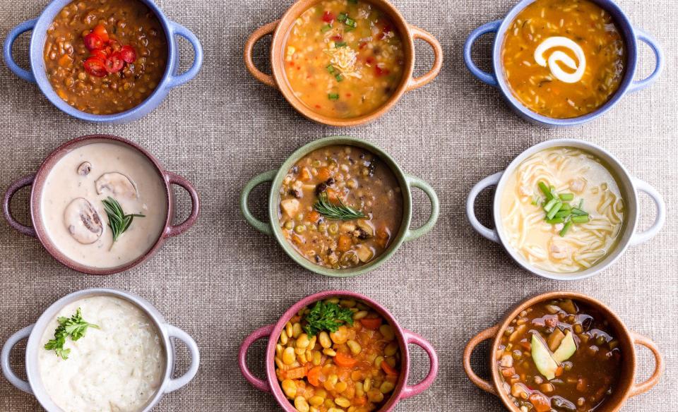 a photo of 9 different colored soup bowls with a different soup simetrically placed in rows