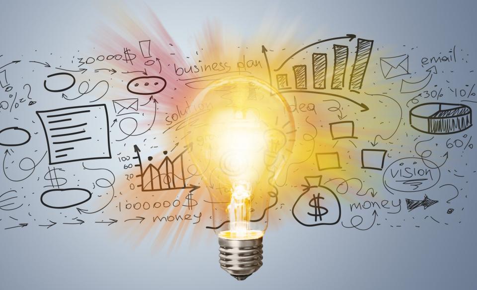 a picture of a lightbulb lit up with sketches in the background of marketing ideas