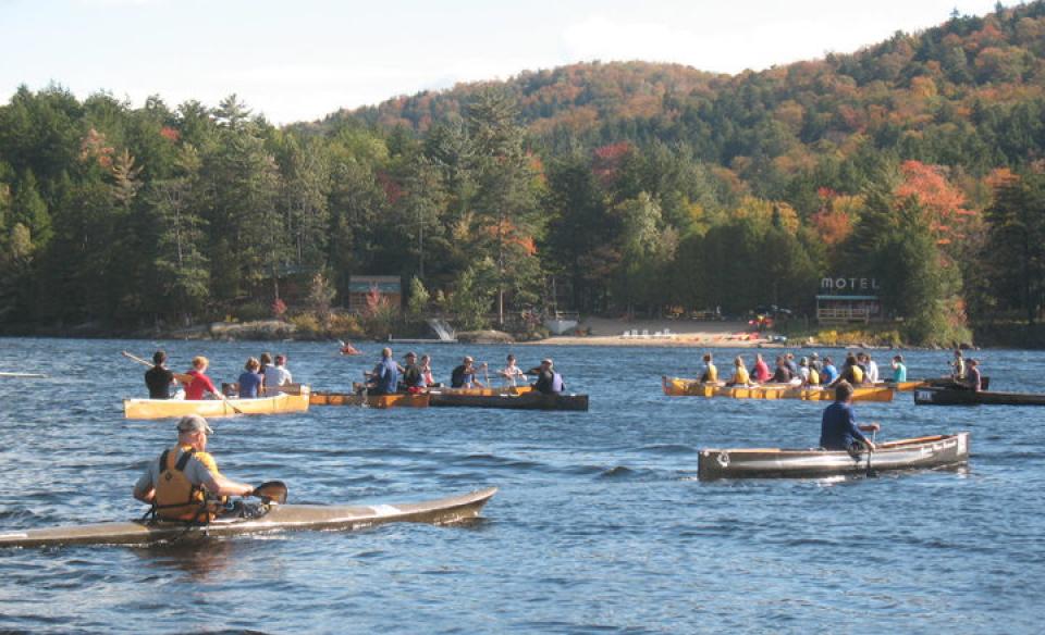several long boats off the shore of long lake beach paddling in the long boat regatta