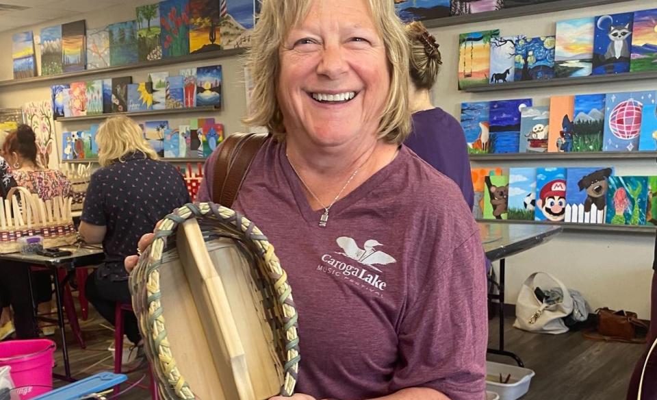 Woman holding up a basket she made with Weave & Wobble instructor