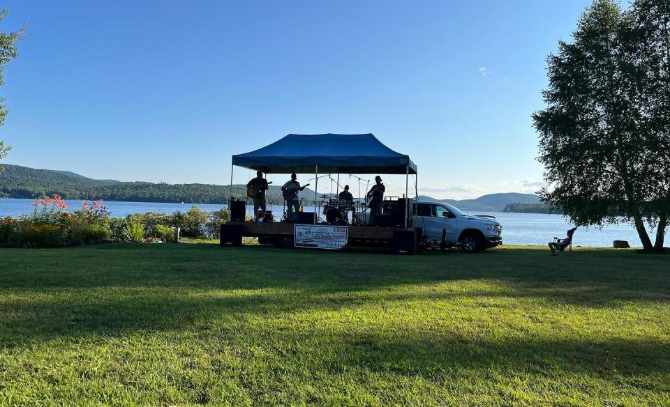 Outdoor band playing on a lakeside stage.