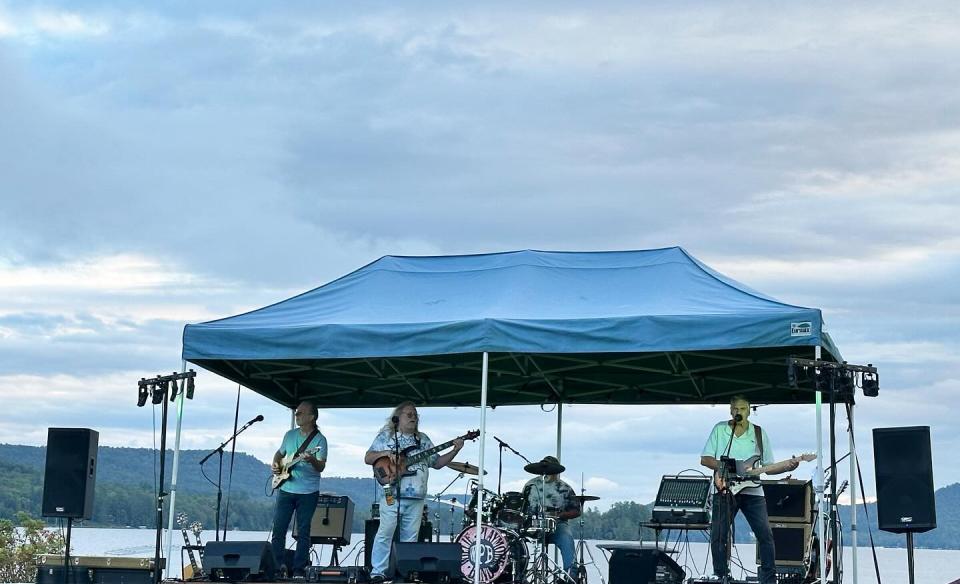 The Willie Playmore Band playing live music outdoors under a tent.