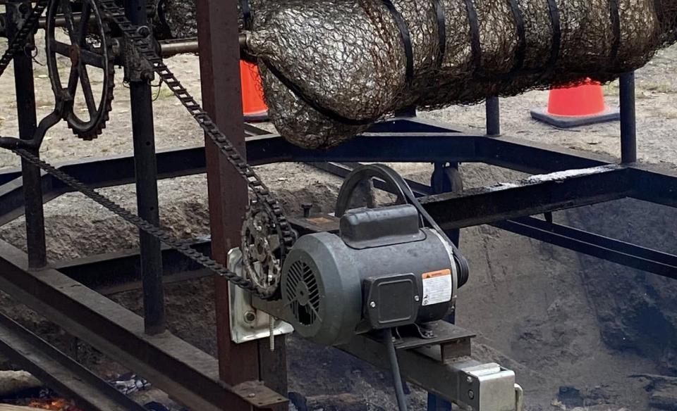 Two pigs on a spit roasting