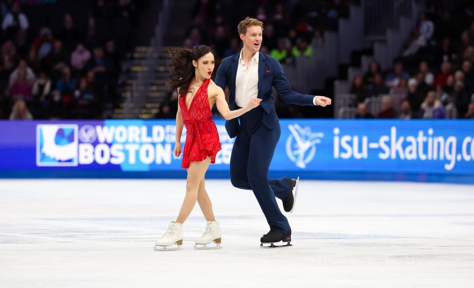 wave to crowds from on the ice while young girls in blue dresses skate behind