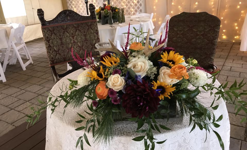 The sweetheart table with a large floral centerpiece.