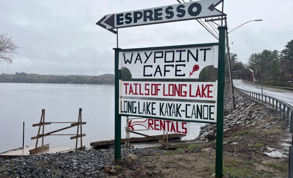 Signs leading the way to Espresso at the Waypoint Cafe next to a dock and the lake