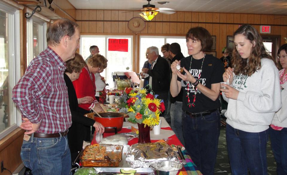 People standing around a table full of tools.