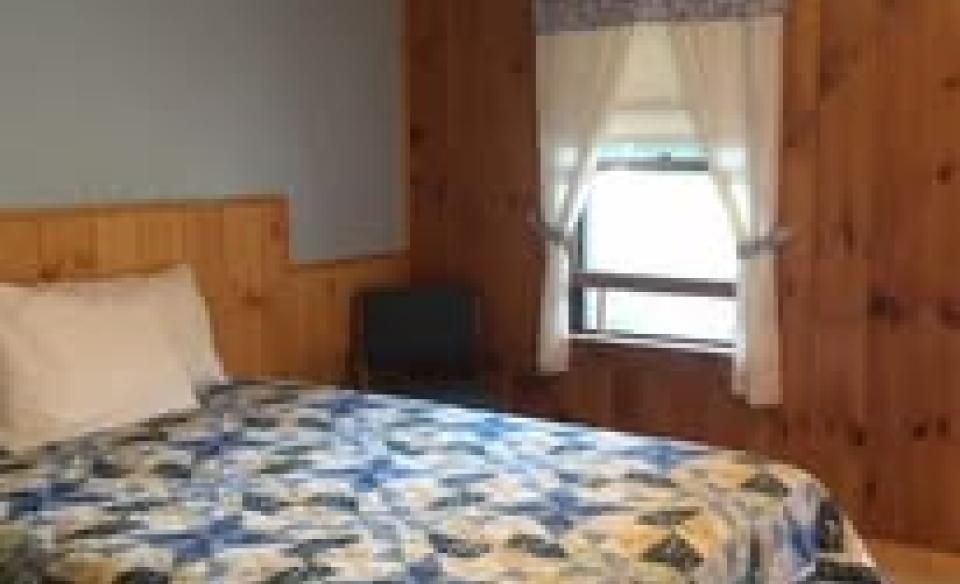 The blue and white quilt on a bed in one of the rooms at The Blueberry Hill Motel.