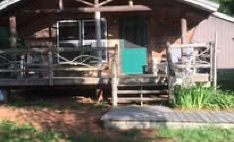 A covered porch with a teal door