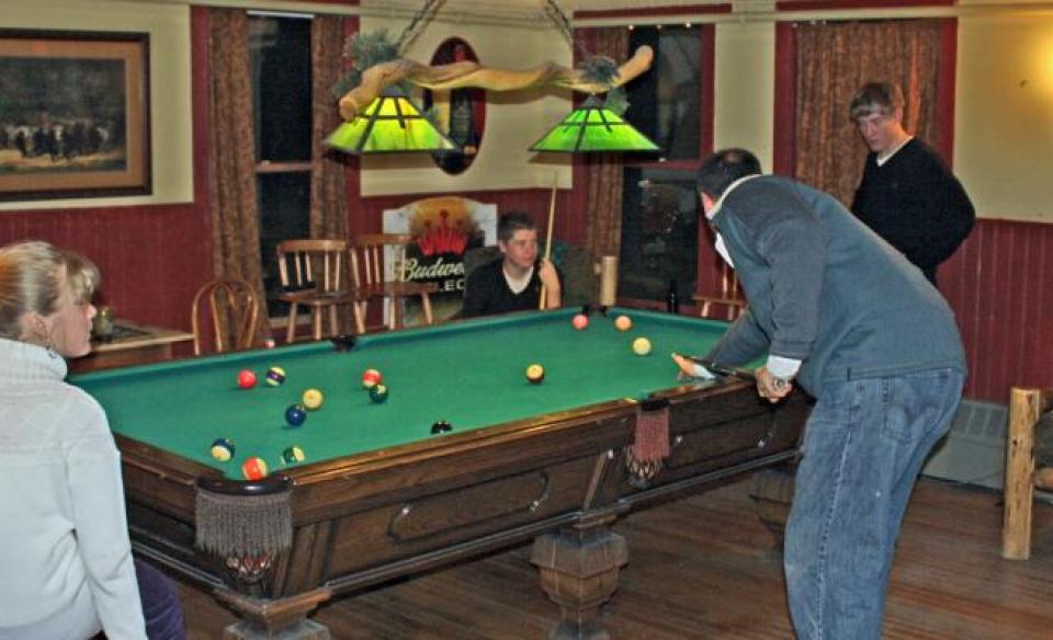 People play billiards.