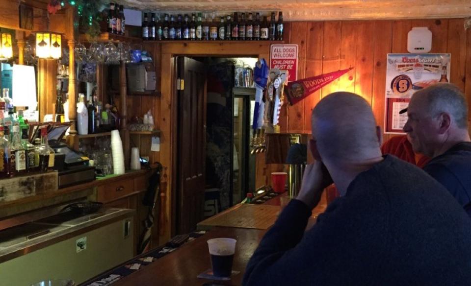 Two men sit at the bar.