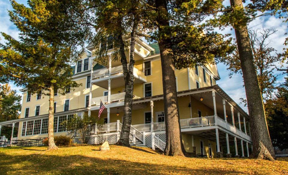 A look at the exterior of The Woods Inn from the lawn under trees.