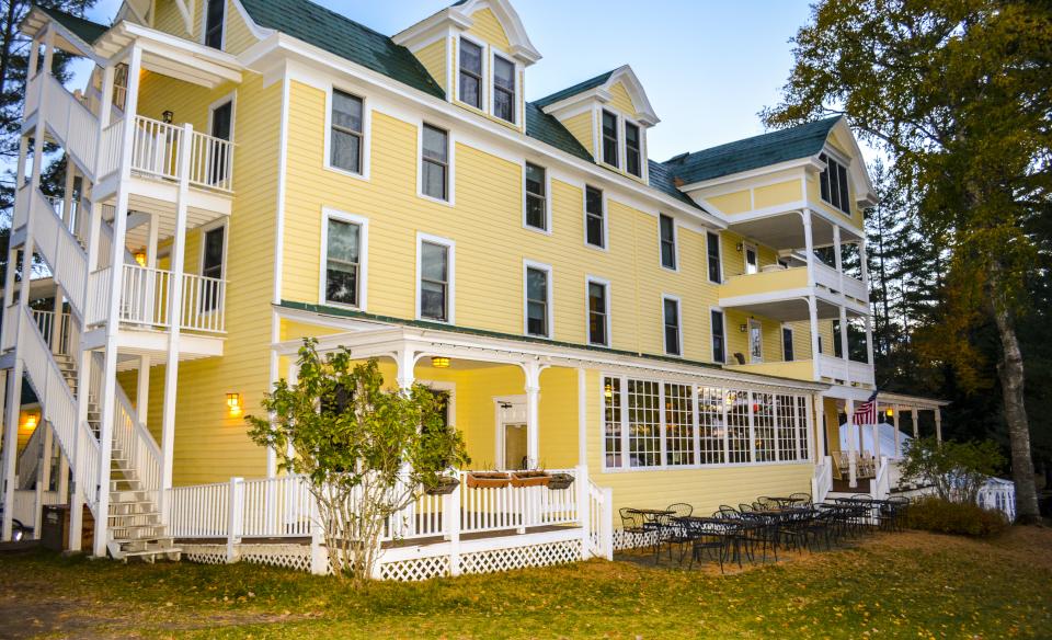 The 4 story yellow building with white trim and black shingles.