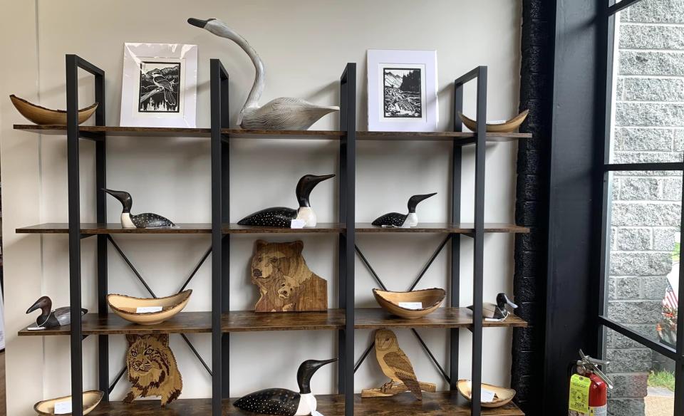 A wooden and metal shelf displaying carvings
