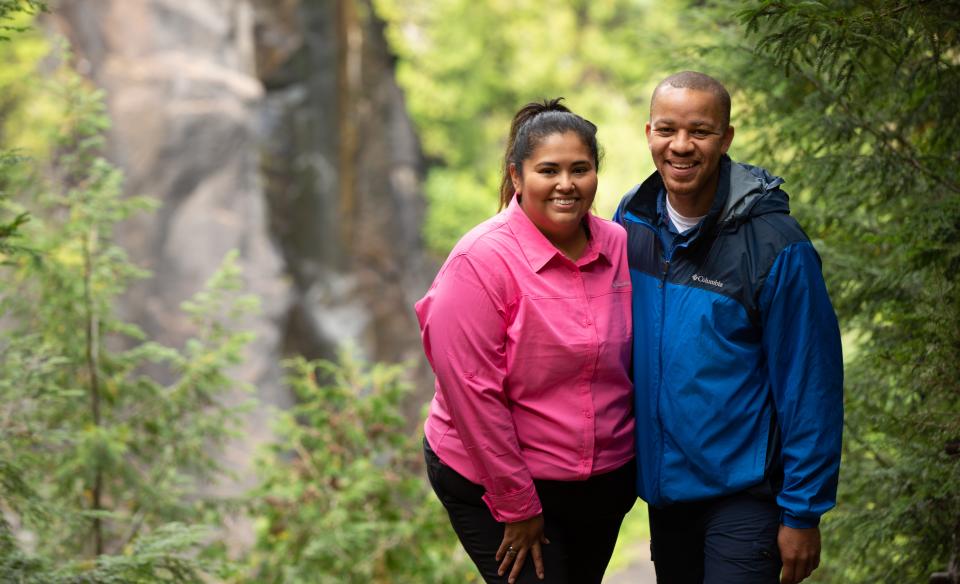 A couple smiles with OK Slip Falls in the background.