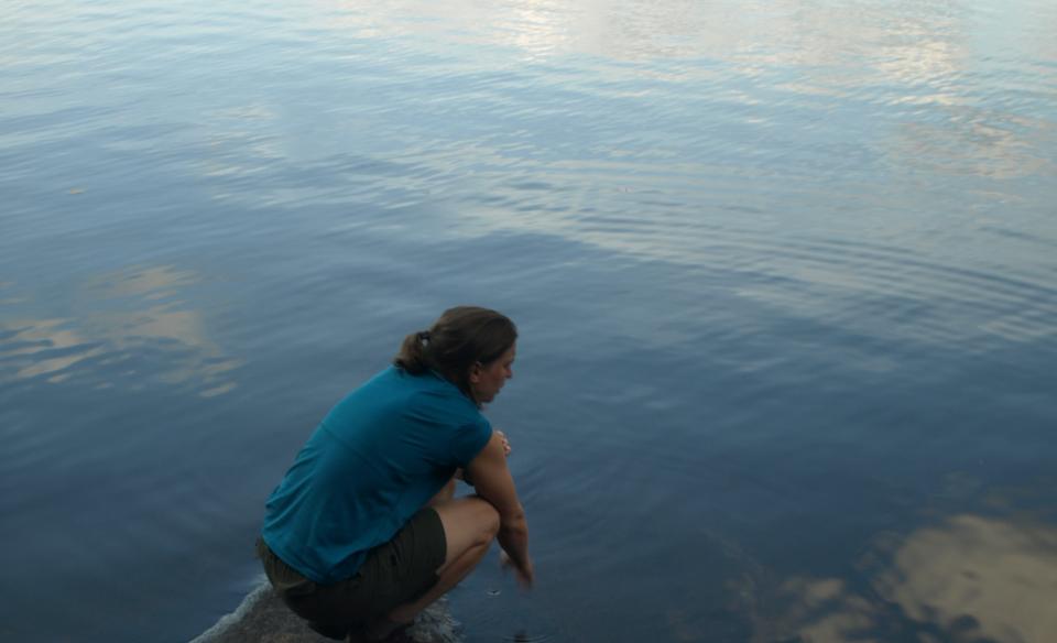 A hiker walks across wooden plank bridging.