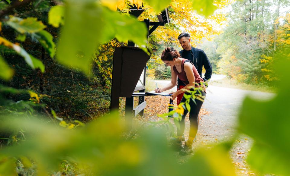 A couple signing into the Goodman Mountain trailhead register