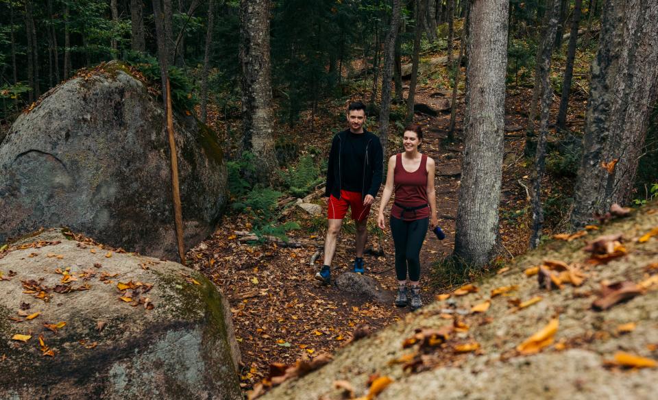 Two hikers approaching large rocks