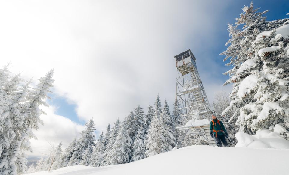 A hiker heading to an ice-encrusted firetower