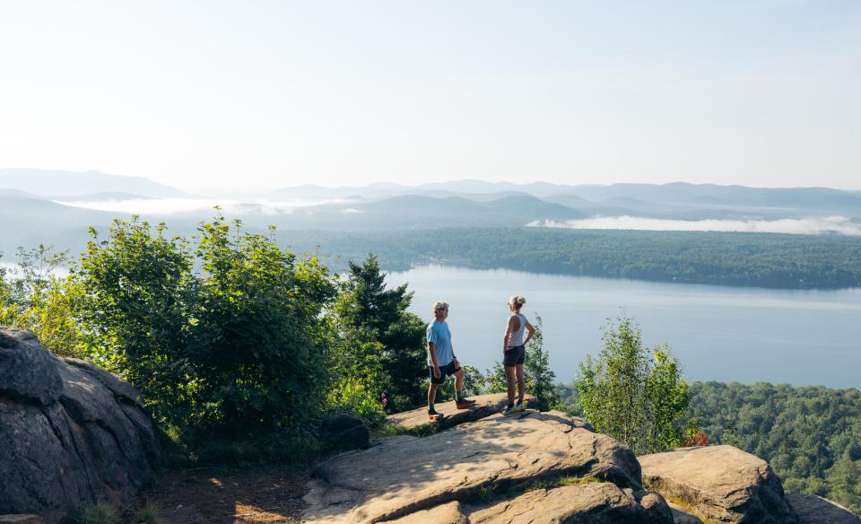 An older couple on a mountain overlooking a lake